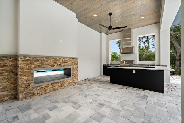 view of patio featuring exterior kitchen, a ceiling fan, and a grill