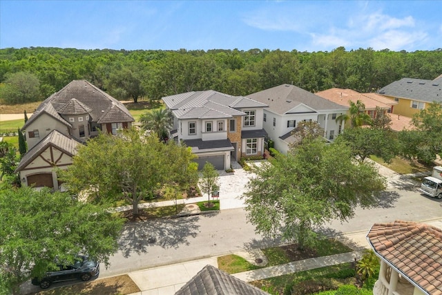 drone / aerial view featuring a residential view and a wooded view