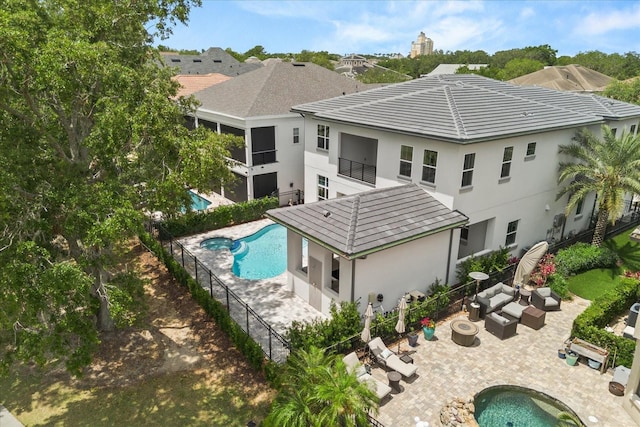 rear view of property featuring a fenced in pool, an outdoor hangout area, a fenced backyard, a patio, and stucco siding
