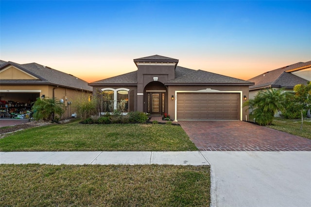 prairie-style house with a garage and a yard