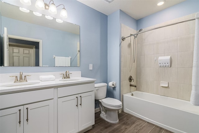 full bathroom featuring vanity, wood-type flooring, toilet, and tiled shower / bath