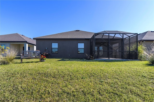 rear view of property with a yard and glass enclosure