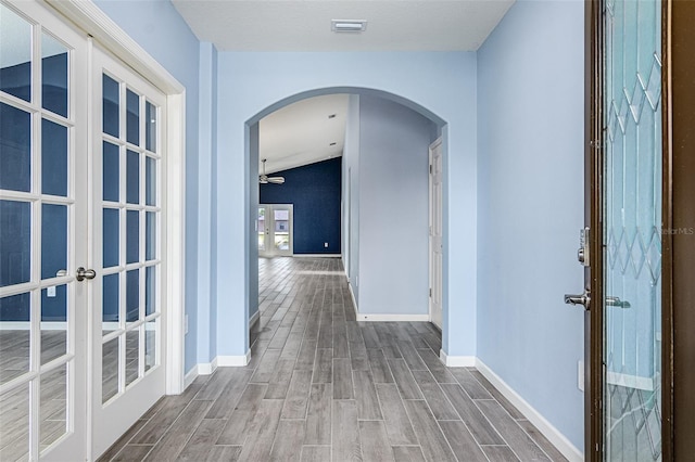 hallway with french doors and hardwood / wood-style floors