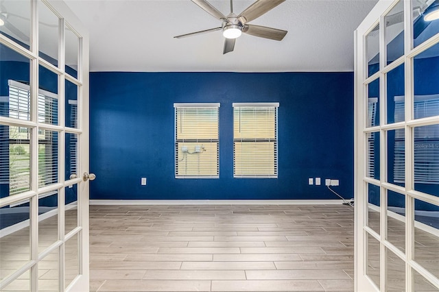 unfurnished room with hardwood / wood-style floors, ceiling fan, and french doors