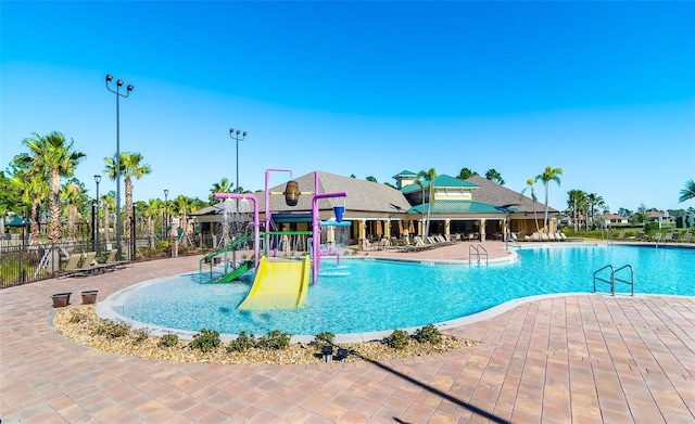 view of swimming pool featuring a patio area and a playground