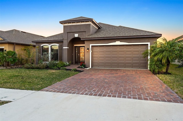 view of front facade with a garage and a lawn