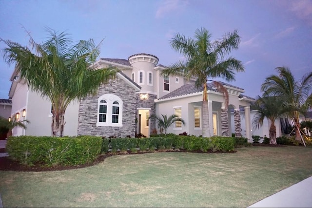 mediterranean / spanish-style home featuring a yard