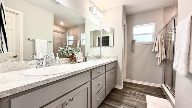 bathroom featuring hardwood / wood-style floors, vanity, and a shower with door