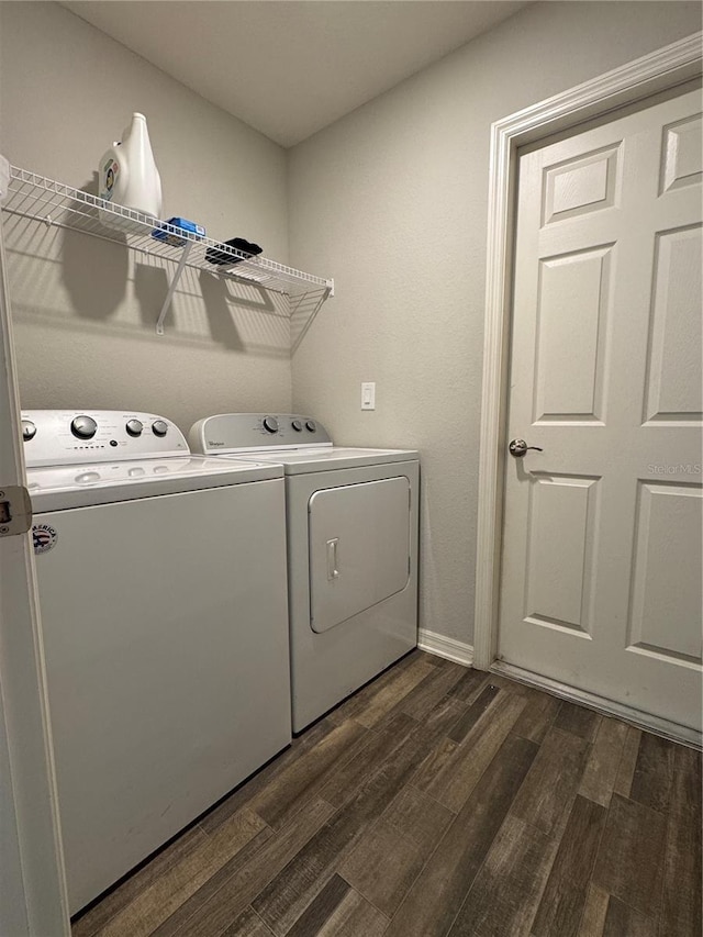 laundry room with washer and dryer and dark wood-type flooring