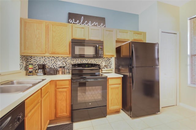 kitchen featuring black appliances, light tile patterned floors, sink, and tasteful backsplash