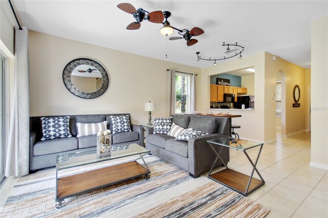 tiled living room featuring ceiling fan and rail lighting