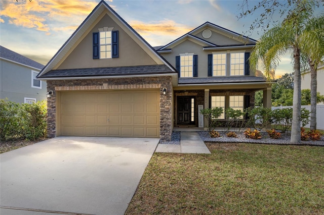 1624 Valmont Ln, Apopka, FL 32703 - traditional home with covered porch, stucco siding, a garage, and stone siding