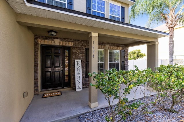 view of exterior entry featuring covered porch