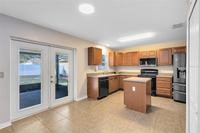 kitchen featuring sink, a kitchen island, black appliances, and light tile patterned floors