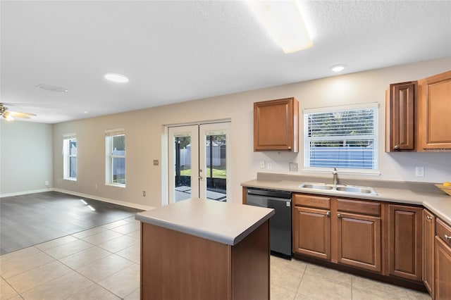 kitchen featuring black dishwasher, a kitchen island, sink, and a wealth of natural light