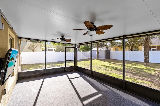 unfurnished sunroom featuring ceiling fan and plenty of natural light