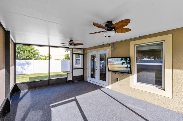 unfurnished sunroom featuring ceiling fan