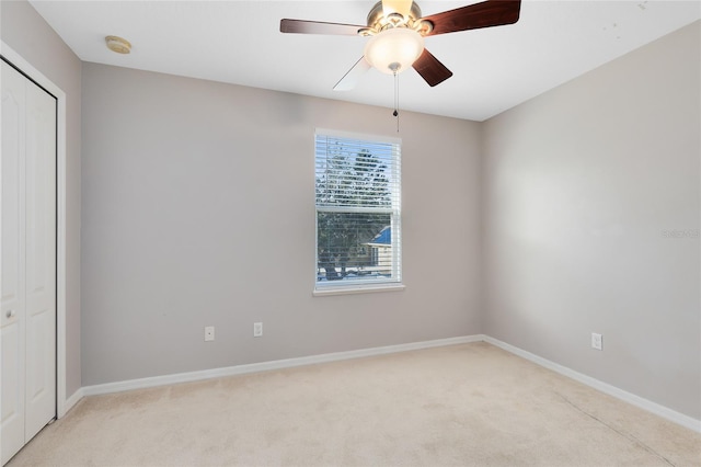 interior space with ceiling fan, light colored carpet, and a closet