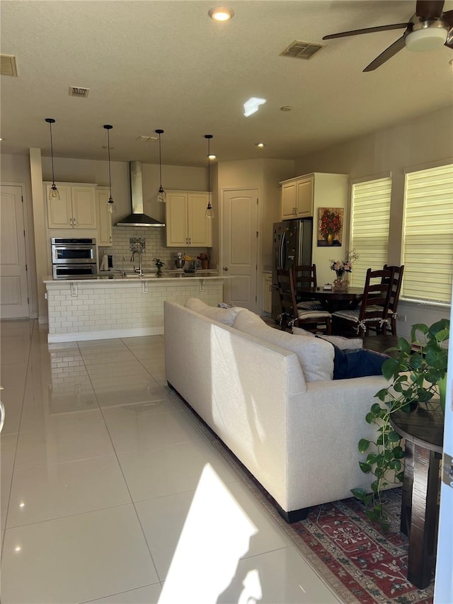 tiled living room featuring ceiling fan and sink