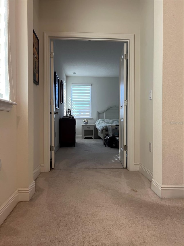 hallway with light colored carpet