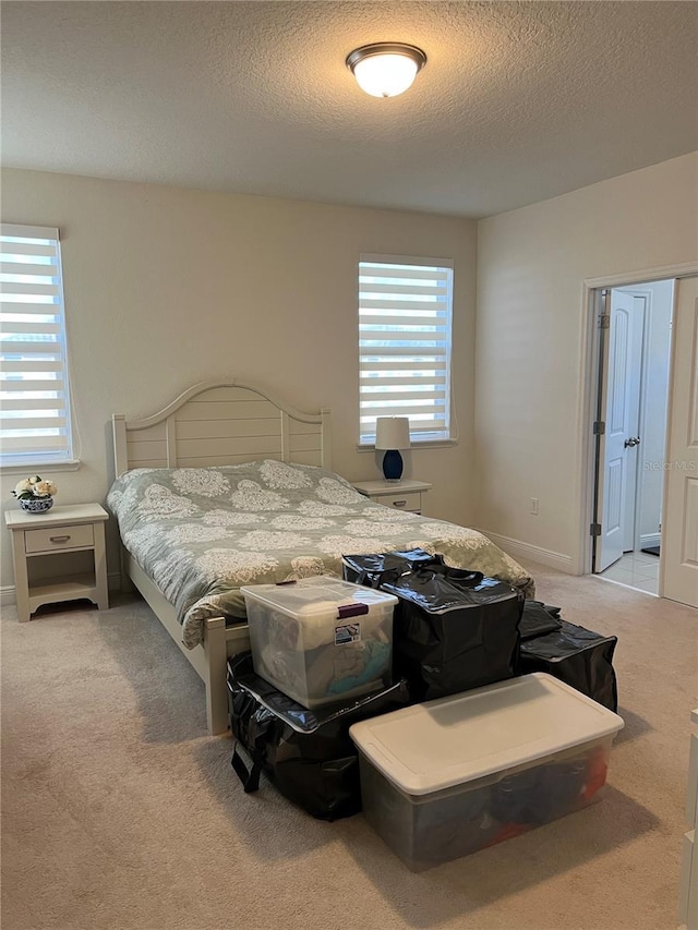 bedroom featuring light carpet and a textured ceiling