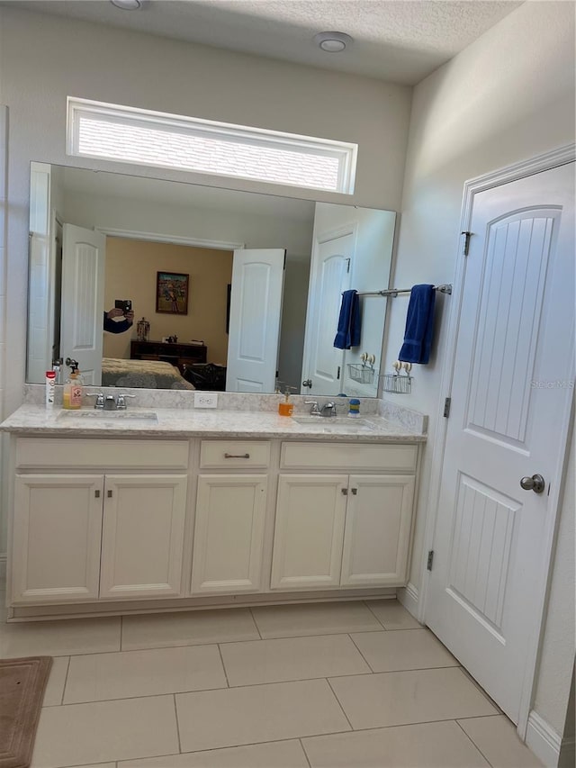 bathroom with tile patterned flooring, vanity, and a textured ceiling