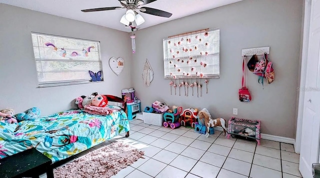 tiled bedroom with ceiling fan and multiple windows