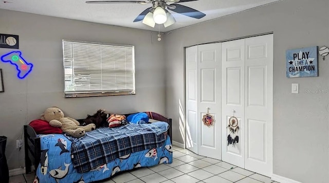 tiled bedroom featuring a textured ceiling, ceiling fan, and a closet