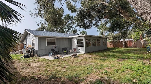 rear view of house featuring a patio area and a yard