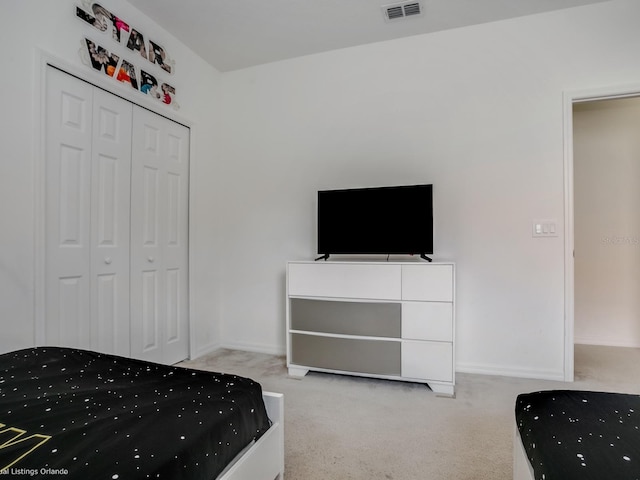 bedroom with light colored carpet and a closet