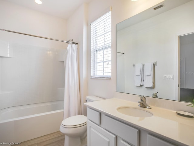 full bathroom with hardwood / wood-style floors, vanity, toilet, and shower / bathtub combination with curtain