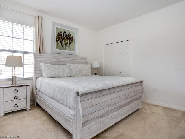 bedroom with multiple windows, light carpet, and a closet