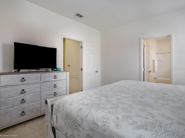 bedroom with light colored carpet and connected bathroom