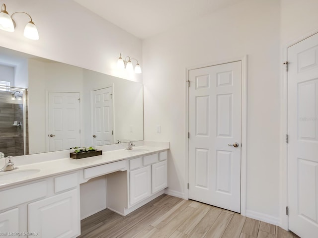 bathroom with hardwood / wood-style flooring, vanity, and walk in shower