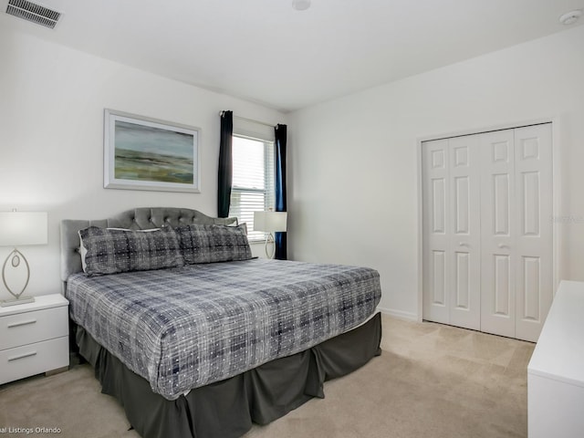 bedroom with light carpet and a closet