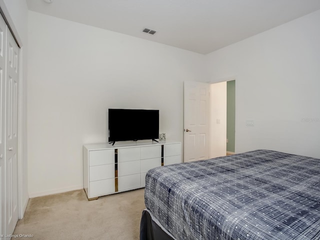 bedroom featuring light carpet and a closet