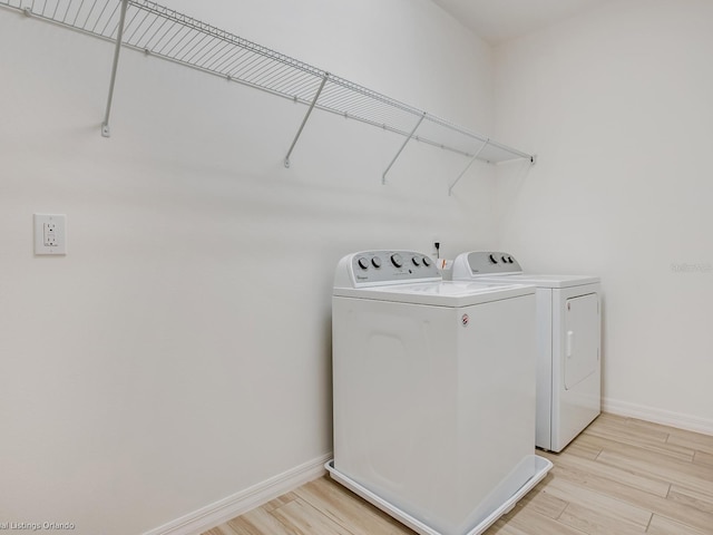 laundry area with light hardwood / wood-style floors and independent washer and dryer