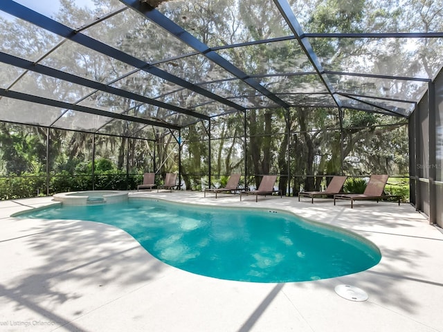 view of swimming pool with glass enclosure, a patio area, and an in ground hot tub