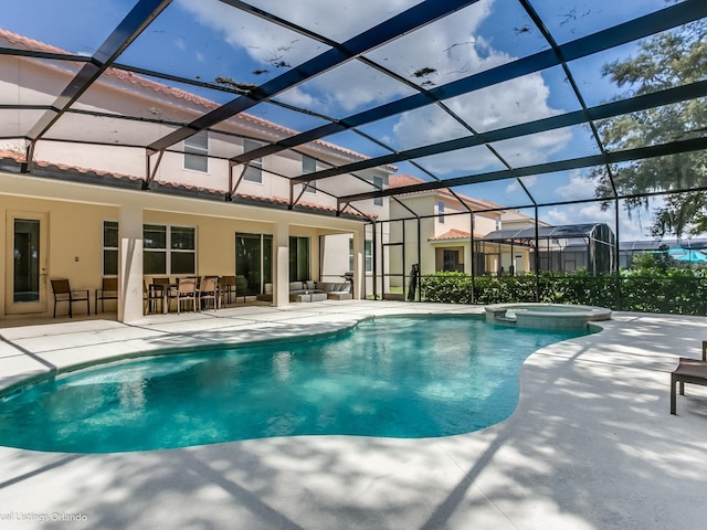 view of pool featuring glass enclosure, an in ground hot tub, a patio area, and exterior bar