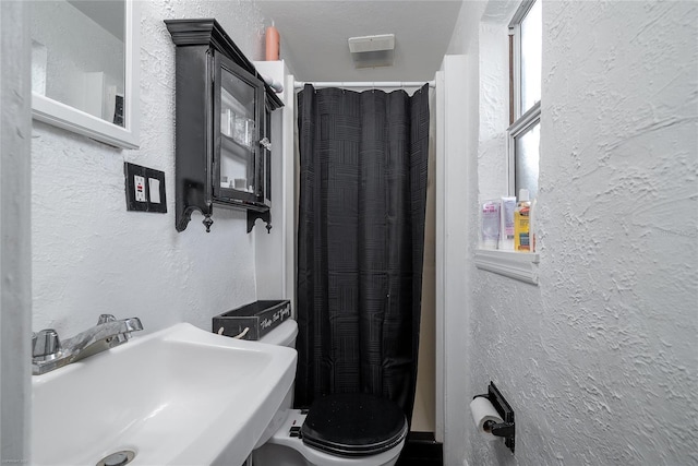 bathroom featuring sink, a healthy amount of sunlight, and toilet