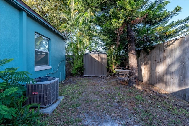 view of yard featuring central AC and a storage unit