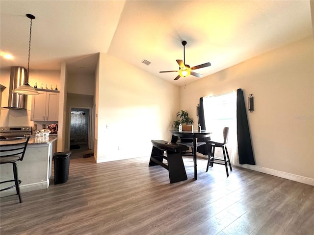 dining room featuring ceiling fan, dark hardwood / wood-style flooring, and lofted ceiling