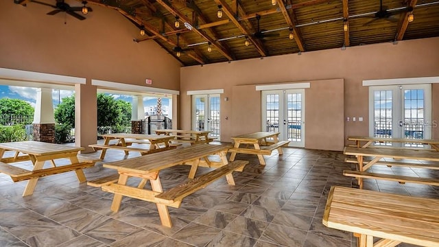 sunroom / solarium featuring vaulted ceiling with beams, ceiling fan, wooden ceiling, and french doors