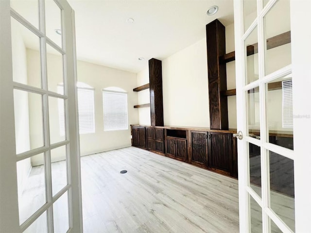 spare room with french doors and light wood-type flooring