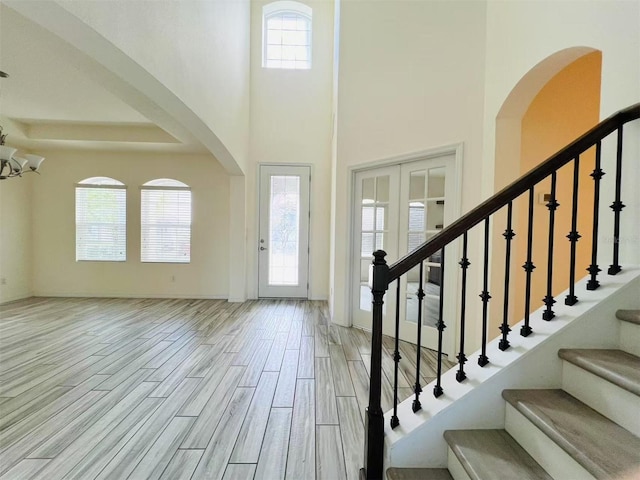 entryway featuring a towering ceiling and an inviting chandelier