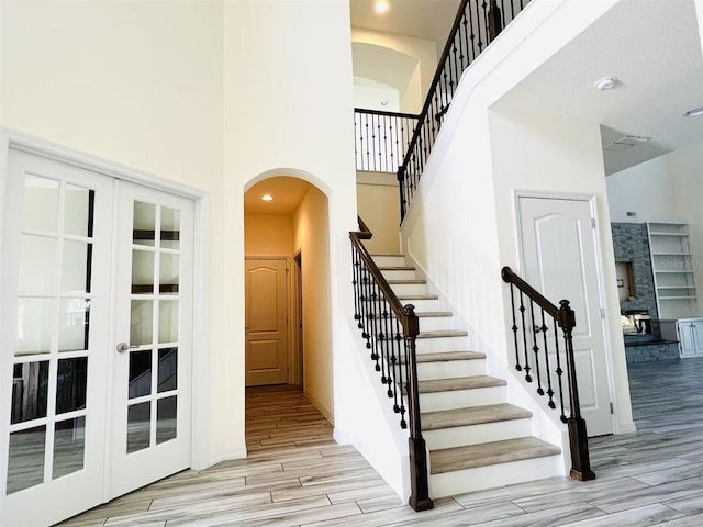 stairs featuring french doors and a towering ceiling