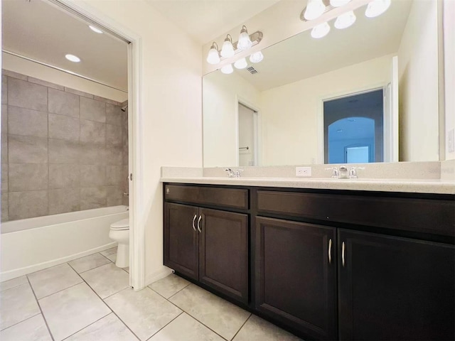 full bathroom featuring tile patterned flooring, vanity, toilet, and tiled shower / bath combo