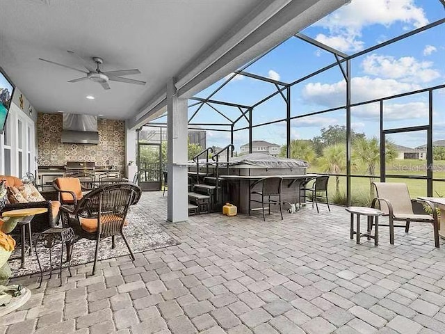 view of patio featuring ceiling fan, an outdoor bar, glass enclosure, and an outdoor kitchen