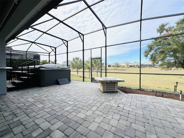 view of patio with a hot tub and glass enclosure