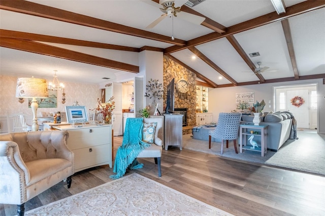 living room with vaulted ceiling with beams, ceiling fan with notable chandelier, and wood-type flooring